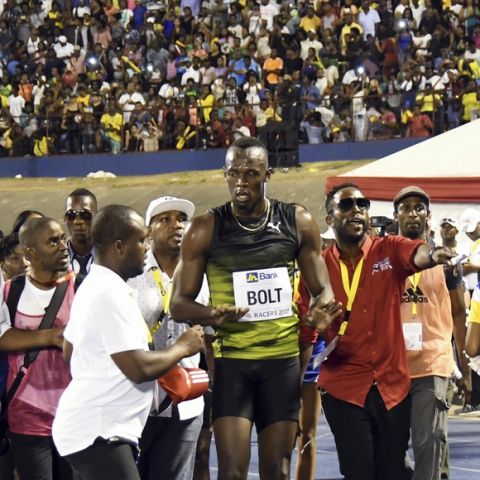 Jamaica's Usain Bolt is surrounded by the crowd after winning the "Salute to a Legend" 100 meters during the Racers Grand Prix at the national stadium in Kingston, Jamaica, Saturday, June 10, 2017. Bolt started his final season with his last race on Jamaican soil and plans to retire from track and field after the 2017 London World Championships in August. (AP Photo/Bryan Cummings)