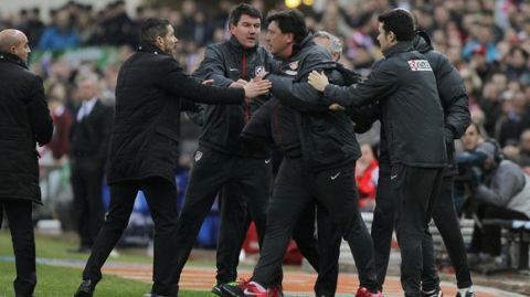 Atletico's assistant coach German Burgos, third right, talks with the referee as Atletico's coach Diego Simeone from Argentina, second left, holds him during a Spanish La Liga soccer match between Atletico de Madrid and Real Madrid at the Vicente Calderon stadium in Madrid, Spain, Sunday, March 2, 2014. (AP Photo/Andres Kudacki)