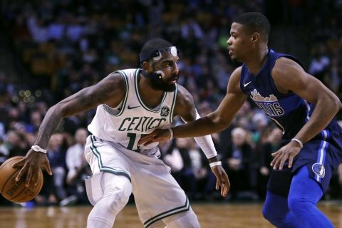 Boston Celtics guard Kyrie Irving, drives to the basket against Dallas Mavericks guard Dennis Smith Jr., right, during the first quarter of an NBA basketball game in Boston, Wednesday, Dec. 6, 2017. Irving scored 23 points as the Celtics defeated the Mavericks 97-90. (AP Photo/Charles Krupa)