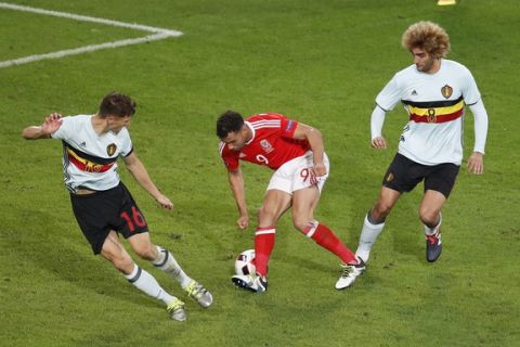 Wales' Hal Robson Kanu, center, controls the ball between Belgium's Thomas Meunier, left, and Marouane Fellaini before scoring his team's second goal during the Euro 2016 quarterfinal soccer match between Wales and Belgium, at the Pierre Mauroy stadium in Villeneuve dAscq, near Lille, France, Friday, July 1, 2016. (AP Photo/Michael Sohn)