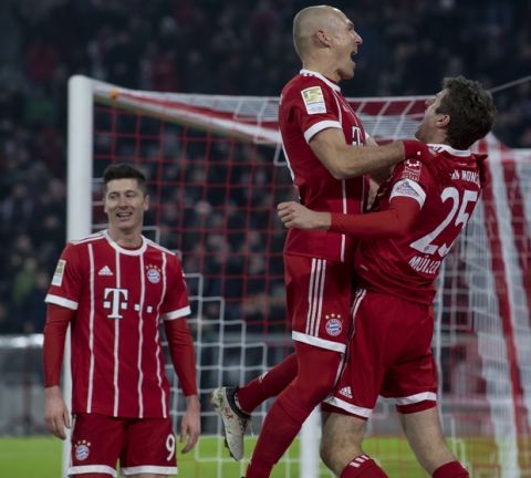 Bayern's Thomas Mueller, right, celebrates with his teammates Arjen Robben and Robert Lewandowski, left, after scoring his side's second goal during the German Bundesliga soccer match between FC Bayern Munich and FC Schalke 04 in Munich, southern Germany, Saturday, Feb. 10. 2018. (Sven Hoppe/dpa via AP)