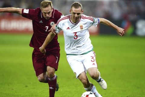 Mihaly Korhut of Hungary, right, vies for the ball with Aleksejs Visnakovks of Latvia during the World Cup Group B qualifying soccer match between Latvia and Hungary at the Skonto Stadium in Riga, Latvia, Monday, Oct. 10, 2016. (Peter Kollanyi/MTI via AP)