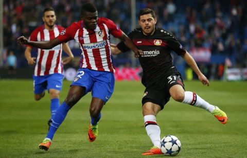 Leverkusen's Kevin Volland, right, is challenged by Atletico's Thomas Partey during the Champions League round of 16 second leg soccer match between Atletico Madrid and Bayer Leverkusen at the Vicente Calderon stadium in Madrid, Spain, Wednesday, March 15, 2017. (AP Photo/Daniel Ochoa de Olza)