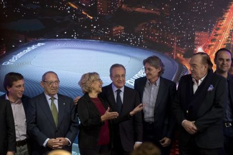 The Mayor of Madrid, Manuela Carmena, 3rd from left and Real Madrid's President Florentino Perez 4th from left pose with staff from Real Madrid and the City Hall in front of a artist's image of the proposed new Santiago Bernabeu stadium during a presentation to remodel the stadium in Madrid, Spain, Tuesday, April 2, 2019. (AP Photo/Paul White)