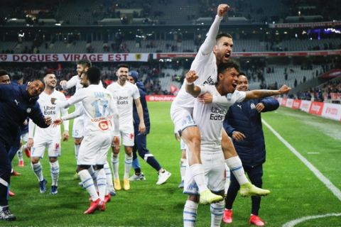 Marseille's players celebrate their victory after the French League One soccer match between Lille and Marseille at the Lille Metropole stadium in Villeneuve d'Ascq, northern France, Sunday, Feb. 16, 2020. (AP Photo/Michel Spingler)