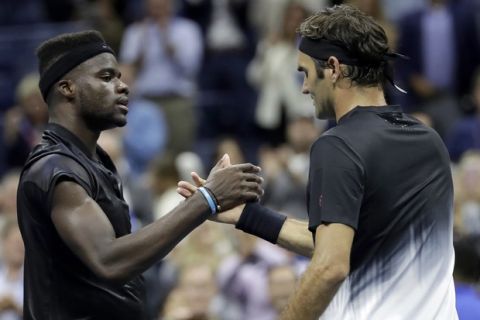 Roger Federer, right, of Switzerland, and Frances Tiafoe, of the United States, shake hands after Federer won their match at the U.S. Open tennis tournament, Tuesday, Aug. 29, 2017, in New York. (AP Photo/Julio Cortez)