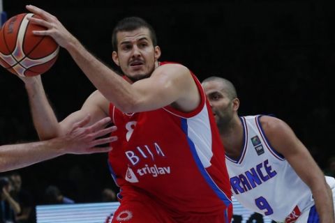 Serbia's Nemanja Bjelica, center, drives past France's Nando De Colo, left, and Tony Parker, right, during the EuroBasket European Basketball Championship bronze medal match, between France and Serbia, at Pierre Mauroy stadium in Lille, northern France, Sunday, Sept. 20, 2015. (AP Photo/Michel Euler)