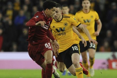 Liverpool's Ki-Jana Hoever, left, vies for the ball with Wolverhampton's Diogo Jota during the English FA Cup third round soccer match between Wolverhampton Wanderers and Liverpool at the Molineux Stadium in Wolverhampton, England, Monday, Jan. 7, 2019. (AP Photo/Rui Vieira)