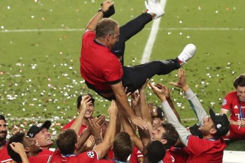 Bayern's head coach Hans-Dieter Flick is tossed in the air by his players as they celebrate after winning the Champions League final soccer match between Paris Saint-Germain and Bayern Munich at the Luz stadium in Lisbon, Portugal, Sunday, Aug. 23, 2020. (Miguel A. Lopes/Pool via AP)