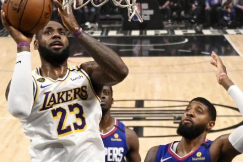 Los Angeles Lakers forward LeBron James, left, shoots as Los Angeles guard Paul George defends during the first half of an NBA basketball game Sunday, March 8, 2020, in Los Angeles. (AP Photo/Mark J. Terrill)
