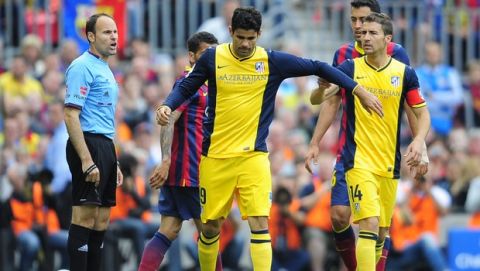 Atletico's Diego Costa, center, gestures after being injured during a Spanish La Liga soccer match between FC Barcelona and Atletico Madrid at the Camp Nou stadium in Barcelona, Spain, Saturday, May 17, 2014. A right referee Mateu Lahoz and at right Atletico's Gabi. (AP Photo/Manu Fernandez)