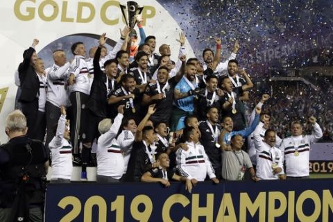 Mexico players celebrate with the trophy after Mexico defeated United States 1-0 in the CONCACAF Gold Cup final soccer match  in Chicago, Sunday, July 7, 2019. (AP Photo/Nam Y. Huh)