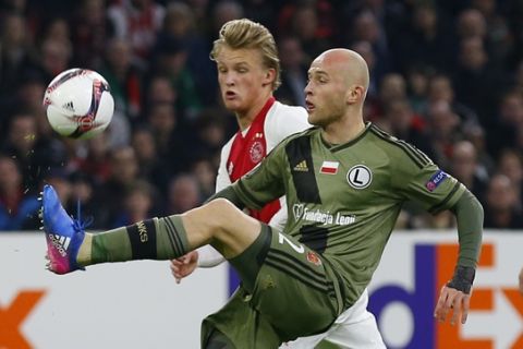 Legia's Michal Pazdan clears the ball before Ajax's Kasper Dolberg, rear, during the Europa League round of 32 second leg soccer match between Ajax and Legia at the Amsterdam ArenA stadium in Amsterdam, Netherlands, Thursday, Feb. 23, 2017. (AP Photo/Peter Dejong)