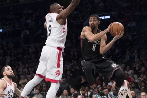 Brooklyn Nets guard Spencer Dinwiddie (8) passes the ball around Toronto Raptors forward Serge Ibaka (9) during the second half of an NBA basketball game, Friday, Dec. 7, 2018, in New York. (AP Photo/Mary Altaffer)