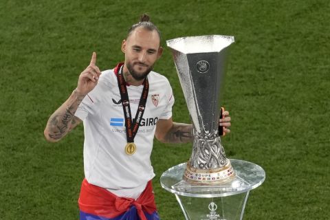 Sevilla's Nemanja Gudelj poses next to the trophy after the Europa League final soccer match between Sevilla and Roma, at the Puskas Arena in Budapest, Hungary, Wednesday, May 31, 2023. (AP Photo/Darko Vojinovic)
