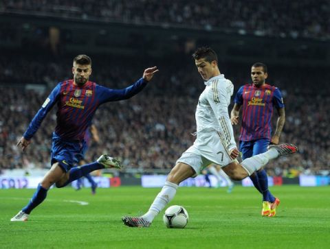 MADRID, SPAIN - JANUARY 18:  Cristiano Ronaldo of Real Madrid strikes to score his sides opening goal during the Copa del Rey quarter final match between Real Madrid and Barcelona at Estadio Santiago Bernabeu on January 18, 2012 in Madrid, Spain.  (Photo by Jasper Juinen/Getty Images)