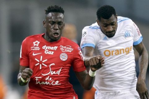 Montpellier's Junior Sambia, left, challenges for the ball with Marseille's Andre-Franck Zambo Anguissa, during the League One soccer match between Marseille and Montpellier at the Velodrome stadium, in Marseille, southern France, Sunday, April 8, 2018. (AP Photo/Claude Paris)
