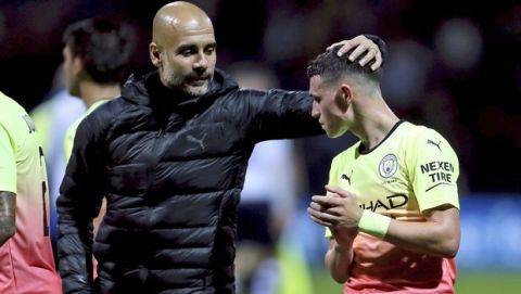 Manchester City manager Pep Guardiola, left, congratulates Phil Foden after an English League Cup soccer match between between Manchester City and Preston North End, Tuesday, Sept. 24, 2019, at Deepdale Stadium in Preston, England. (Richard Sellers/PA via AP)