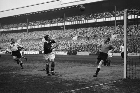 England playing Germany at football, at the Tottenham Hotspur football club ground, White Hart Lane, north London on Dec. 4, 1935. Hans Jakob, the German Goalkeeper, is seen running across the goalmouth to intercept a center during an attack by the English forwards. (AP Photo/Staff/Putnam)
