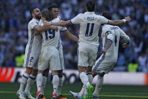Real Madrid's Pepe, third left, celebrates with teammates after scoring the opening goal against Atletico Madrid during the La Liga soccer match between Real Madrid and Atletico Madrid at the Santiago Bernabeu stadium in Madrid, Saturday, April 8, 2017. Pepe scored once and the match ended in a 1-1 draw. (AP Photo/Francisco Seco)