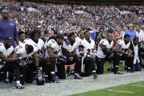 Baltimore Ravens players, including former player Ray Lewis, second from right, kneel down during the playing of the U.S. national anthem before an NFL football game against the Jacksonville Jaguars at Wembley Stadium in London, Sunday Sept. 24, 2017. (AP Photo/Matt Dunham)