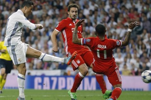 Real Madrid's Cristiano Ronaldo scores passing Bayern's Douglas Costa, right, during the Champions League quarterfinal second leg soccer match between Real Madrid and Bayern Munich at Santiago Bernabeu stadium in Madrid, Spain, Tuesday April 18, 2017. (AP Photo/Francisco Seco)