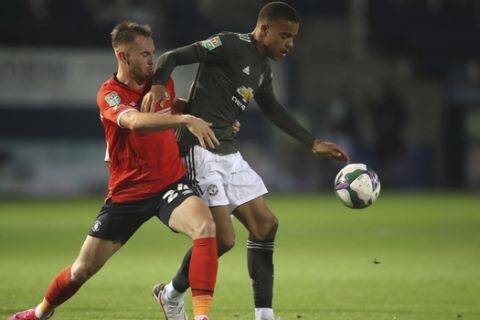 Manchester United's Mason Greenwood, right, is challenged by Luton Town's Rhys Norrington-Davies during the English League Cup 3rd round soccer match between Luton Town and Manchester United, Tuesday, Sept. 22, 2020, at Kenilworth Road in Luton, England. (Nick Potts/Pool via AP)