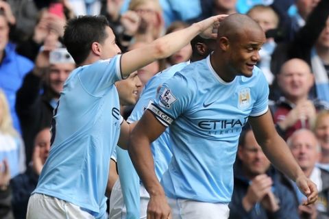 Manchester City's Vincent Kompany, right, celebrates after scoring his side's second goal with his teammate Samir Nasri, left, during the English Premier League soccer match between Manchester City and West Ham at the Etihad Stadium in Manchester, England, Sunday May 11, 2014.  (AP Photo/Jon Super)