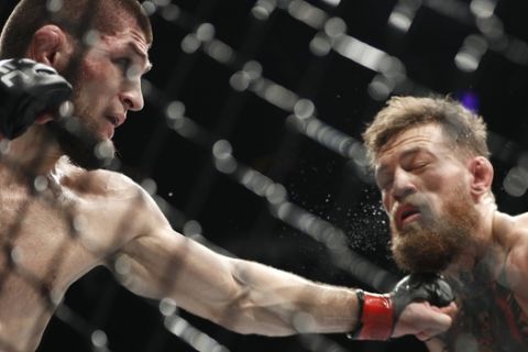 FILE - In this Oct. 6, 2018, file photo, Khabib Nurmagomedov, left, punches Conor McGregor during a lightweight title mixed martial arts bout at UFC 229 in Las Vegas. Nurmagomedov has not fought in the 11 months since he punctuated his star-making victory over McGregor at UFC 229 in Las Vegas by scaling the fence and jumping into the crowd to fight McGregors entourage. (AP Photo/John Locher, File)