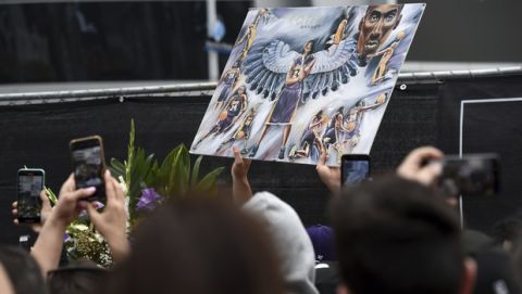 Fans take photos of artwork featuring former Los Angeles Lakers basketball player Kobe Bryant outside of the Staples Center prior to the start of the 62nd annual Grammy Awards at the Staples Center on Sunday, Jan. 26, 2020, in Los Angeles. Bryant died Sunday in a helicopter crash near Calabasas, Calif. He was 41. (AP Photo/Chris Pizzello)