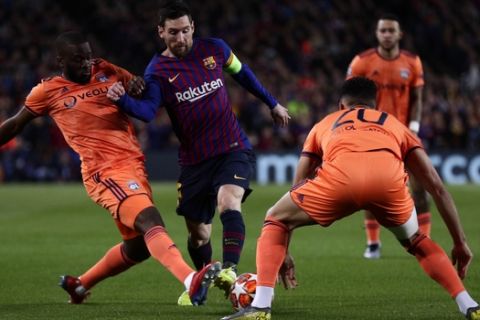 Barcelona forward Lionel Messi, center, goes for the ball past Lyon defender Fernando Marcal, right, and Lyon defender Marcelo during the Champions League round of 16, 2nd leg, soccer match between FC Barcelona and Olympique Lyon at the Camp Nou stadium in Barcelona, Spain, Wednesday, March 13, 2019. (AP Photo/Manu Fernandez)