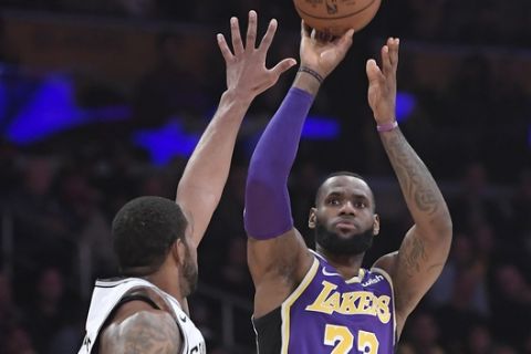 Los Angeles Lakers forward LeBron James, right, shoots as San Antonio Spurs forward LaMarcus Aldridge defends during the first half of an NBA basketball game, Wednesday, Dec. 5, 2018, in Los Angeles. (AP Photo/Mark J. Terrill)