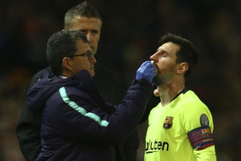Barcelona's Lionel Messi receives medical assistance during the Champions League quarterfinal, first leg, soccer match between Manchester United and FC Barcelona at Old Trafford stadium in Manchester, England, Wednesday, April 10, 2019. (AP Photo/Dave Thompson)