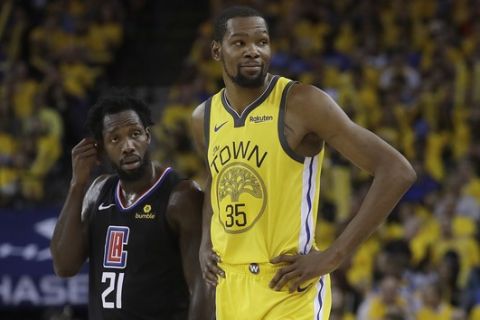 Golden State Warriors forward Kevin Durant (35) stands next to Los Angeles Clippers guard Patrick Beverley (21) during the second half of Game 2 of a first-round NBA basketball playoff series in Oakland, Calif., Monday, April 15, 2019. (AP Photo/Jeff Chiu)