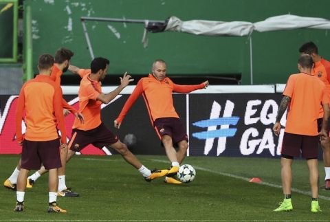 Barcelona's Andres Iniesta, center right, goes for the ball with Sergio Busquets during a training session at the Alvalade stadium in Lisbon, Tuesday Sept. 26, 2017. Barcelona will play Sporting CP in a Champions League, Group D soccer match Wednesday. (AP Photo/Armando Franca)