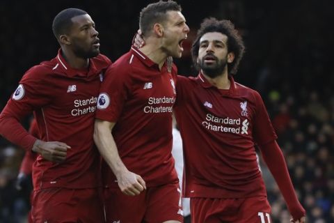 Liverpool's James Milner, center, celebrates after scoring his side's second goal, during the English Premier League soccer match between Fulham and Liverpool at Craven Cottage stadium in London, Sunday, March 17, 2019. (AP Photo/Kirsty Wigglesworth)