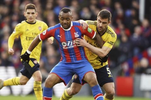 Crystal Palace's Jordan Ayew, foreground, and Arsenal's Sokratis Papastathopoulos battle for the ball, during the English Premier League soccer match between Crystal Palace and Arsenal, at Selhurst Park, in London, Saturday,  Jan. 11, 2020. (Tess Derry/PA via AP)