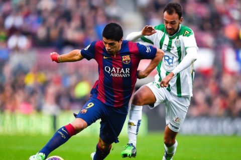 BARCELONA, SPAIN - DECEMBER 20:  Luis Suarez of FC Barcelona competes for the ball with David Rodriguez Barrera of Cordoba CF during the La Liga match between FC Barcelona and Cordoba CF at Camp Nou on December 20, 2014 in Barcelona, Spain.  (Photo by David Ramos/Getty Images)