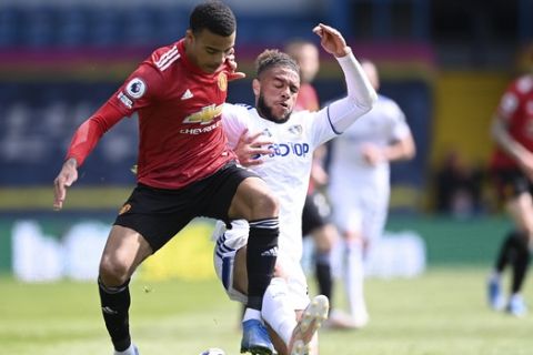 Manchester United's Mason Greenwood is challenged by Leeds United's Tyler Roberts during the English Premier League soccer match between Leeds United and Manchester United at Elland Road in Leeds, England, Sunday April 25, 2021. (Laurence Griffiths/Pool via AP)