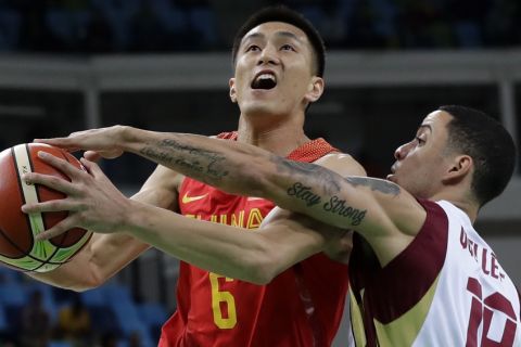 China's Guo Ailun (6) is fouled by Venezuela's Heissler Guillent, right, while driving to the basket during a basketball game at the 2016 Summer Olympics in Rio de Janeiro, Brazil, Wednesday, Aug. 10, 2016. (AP Photo/Charlie Neibergall)