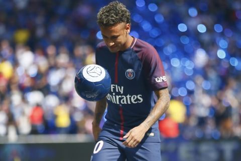 Brazilian soccer star Neymar kicks a ball at the Parc des Princes stadium in Paris, Saturday, Aug. 5, 2017, during his official presentation to fans ahead of Paris Saint-Germain's season opening match against Amiens. Neymar would not play in the club's season opener as the French football league did not receive the player's international transfer certificate before Friday's night deadline. The Brazil star became the most expensive player in soccer history after completing his blockbuster transfer from Barcelona for 222 million euros ($262 million) on Thursday. (AP Photo/Francois Mori)