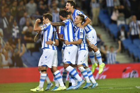 Real Sociedad's Mikel Oyarzabal, left, celebrates with teammates after the third goal during the Spanish La Liga soccer match between Real Sociedad and Alaves at Reale Arena stadium, in San Sebastian, northern Spain, Thursday, Sept. 26, 2019. (AP Photo/Alvaro Barrientos)