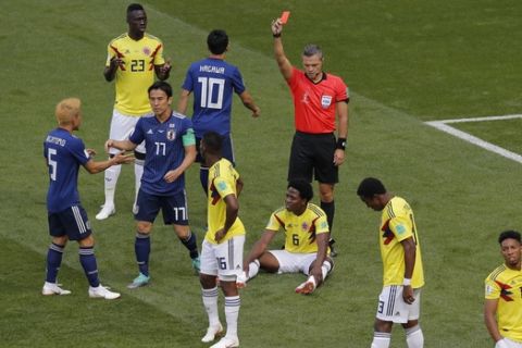 Referee Damir Skomina from Slovenia shows a red card to Colombia's Carlos Sanchez, on the ground, during the group H match between Colombia and Japan at the 2018 soccer World Cup in the Mordavia Arena in Saransk, Russia, Tuesday, June 19, 2018. (AP Photo/Vadim Ghirda)