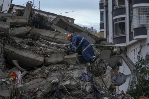 A member of emergency team climbs over a destroyed building as he searches for people in Adana, Turkey, Monday, Feb. 6, 2023. A powerful quake has knocked down multiple buildings in southeast Turkey and Syria and many casualties are feared. (AP Photo/Khalil Hamra)
