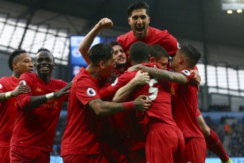 Liverpool players celebrate after scoring the opening goal during the English Premier League soccer match between Manchester City and Liverpool at the Etihad Stadium in Manchester, England, Sunday March 19, 2017. (AP Photo/Dave Thompson)