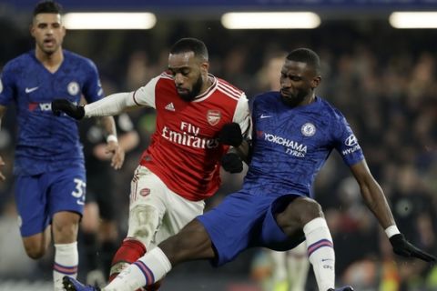 Arsenal's Alexandre Lacazette, center, duels for the ball with Chelsea's Antonio Rudiger during the English Premier League soccer match between Chelsea and Arsenal at Stamford Bridge Stadium in London, Tuesday, Jan. 21, 2020. (AP Photo/Matt Dunham)