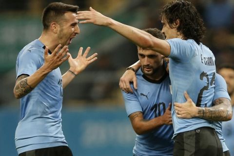 Uruguay's Edinson Cavani, right, celebrates with teammates Giorgian De Arrascaeta, center, and Matias Vecino, left, after scoring a goal against the Czech Republic during their match in the 2018 China Cup International Football Championship in Nanning in southern China's Guangxi province, Friday, March 23, 2018. (Color China Photo via AP)