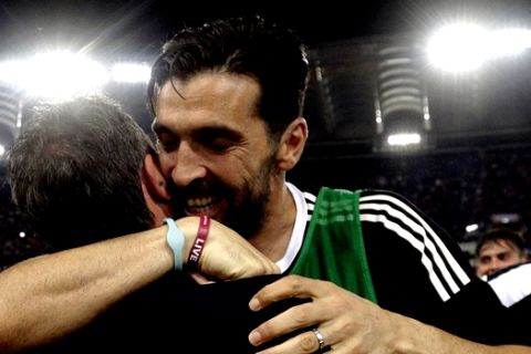 Juventus goalkeeper Gianluigi Buffon celebrates with a team staffer at the end of the Serie A soccer match between Roma and Juventus, at the Rome Olympic stadium, Sunday, May 13, 2018. The match ended in a scoreless draw and Juventus won record-extending seventh straight Serie A title. (AP Photo/Gregorio Borgia)