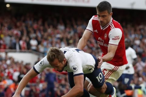 Tottenham's Harry Kane, left, fights for the ball with Arsenal's Sokratis Papastathopoulos during their English Premier League soccer match between Arsenal and Tottenham Hotspur at the Emirates stadium in London, Sunday, Sept. 1, 2019. (AP Photo/Alastair Grant)