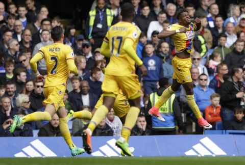 Crystal Palace's Wilfried Zaha, right celebrates after scoring his side's first goal during the English Premier League soccer match between Chelsea and Crystal Palace at Stamford Bridge stadium in London Saturday, April 1, 2017. (AP Photo/Alastair Grant)